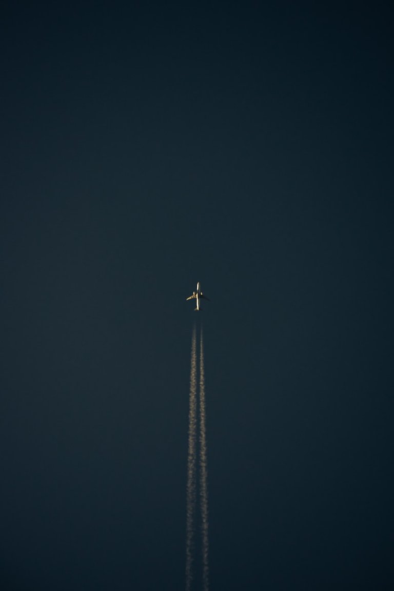 an airplane is flying in the dark sky